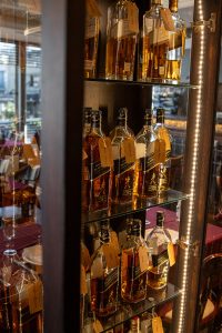 Vitrina del García Whisky Club con botellas de Johnnie Walker etiquetadas