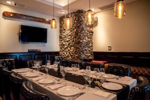 Sala Vip La Cumparsita de García, salón privado con mesa larga y paredes de piedra